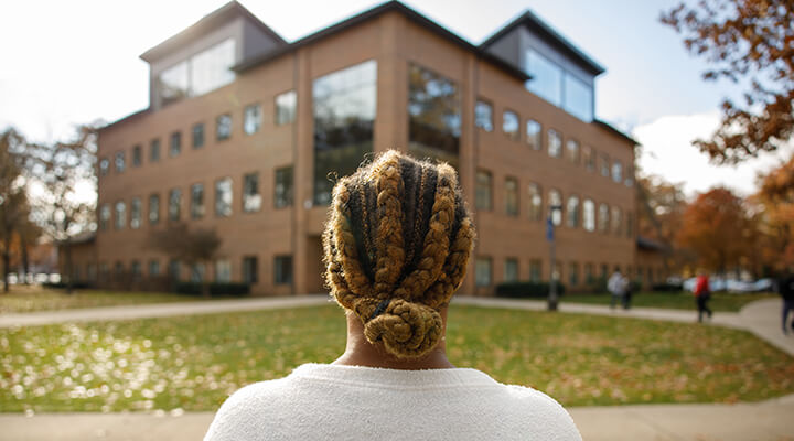 student looks on at the academic center building